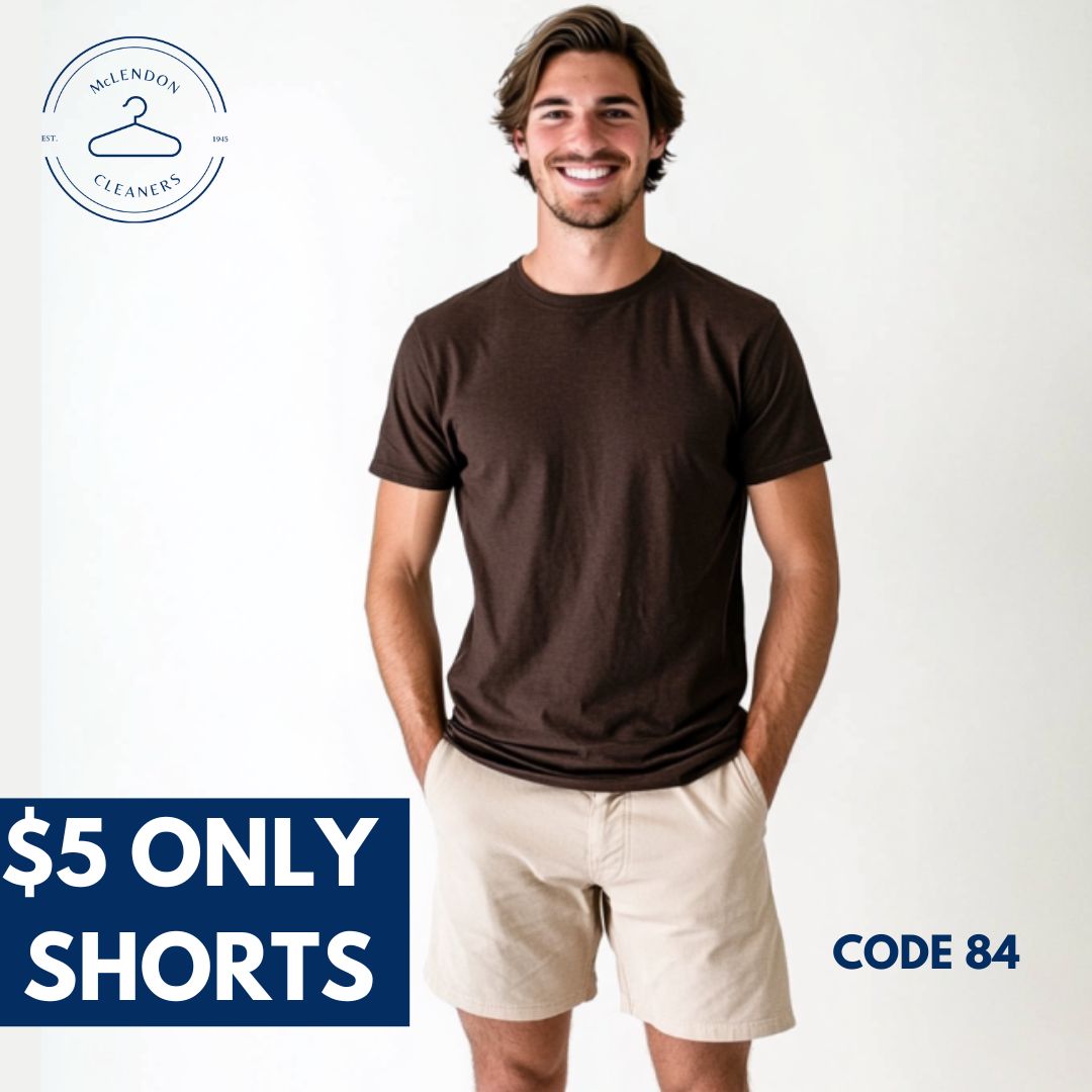 A man wearing a brown t-shirt and beige shorts stands, smiling. Text reads: "$5 Only Shorts," "CODE 84," and "McLendon Cleaners" logo appears in the corner.