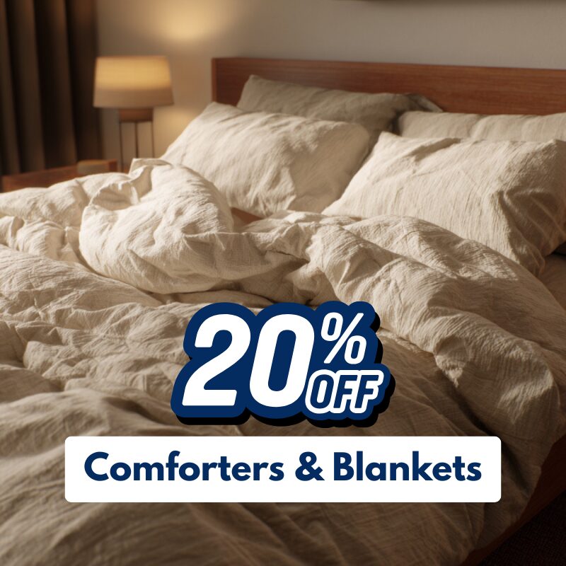 Unmade bed with beige comforter and pillows in a cozy bedroom. Text on image reads "20% off Comforters & Blankets.
