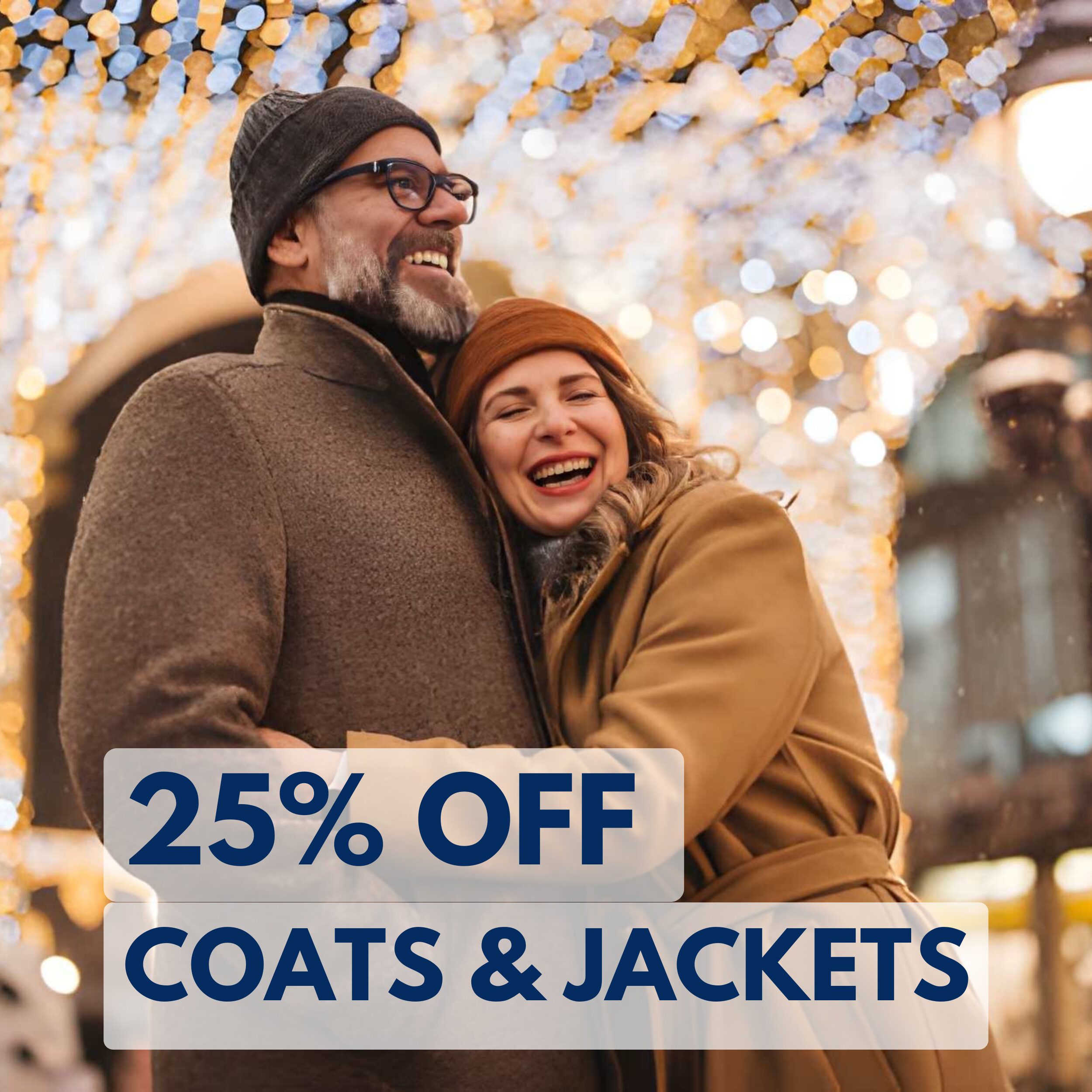 Smiling couple in winter coats embraces outdoors under festive lights. Text reads "25% off coats & jackets.