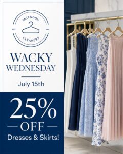 Four dresses and one skirt hang on a rack beside a sign for McLendon Cleaners advertising 25% off dresses and skirts on Wacky Wednesday, July 15th.