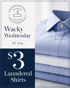Stack of neatly folded dress shirts next to a promo sign reading “Wacky Wednesday 05-Aug $3 Laundered Shirts” for McLendon Cleaners.